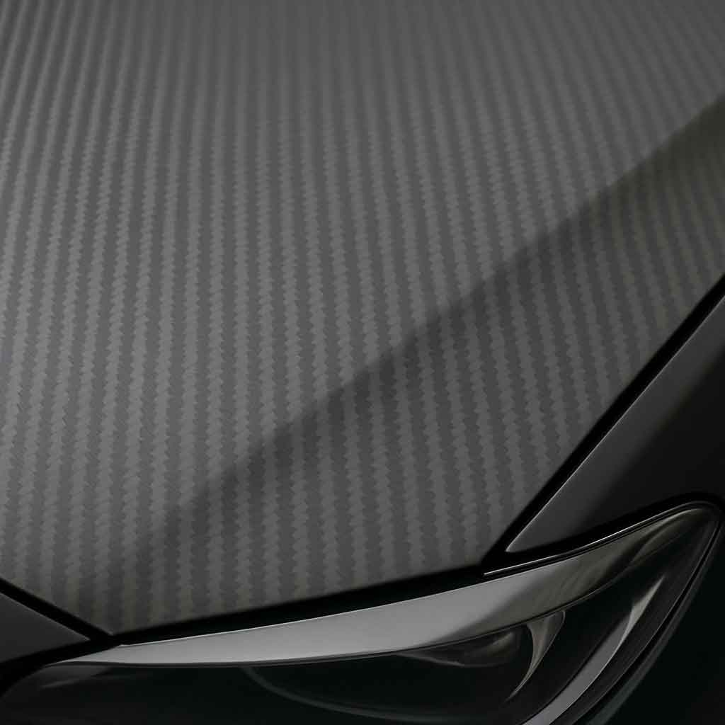 Close-up of a matte carbon fiber wrap on a car hood