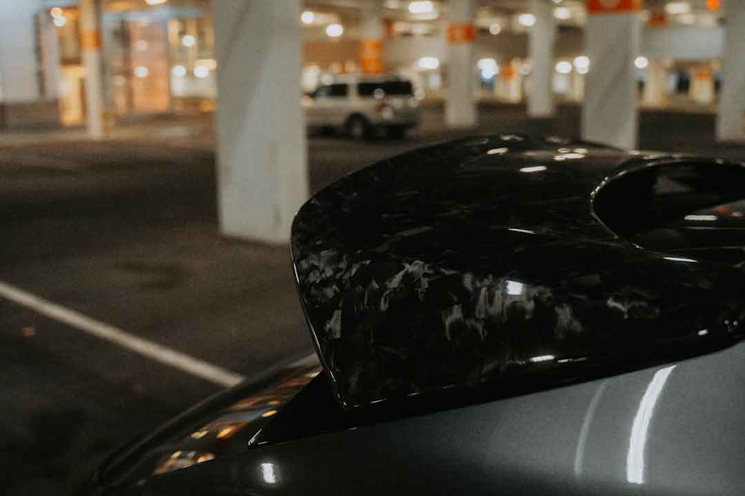 A car being wrapped in carbon fiber vinyl